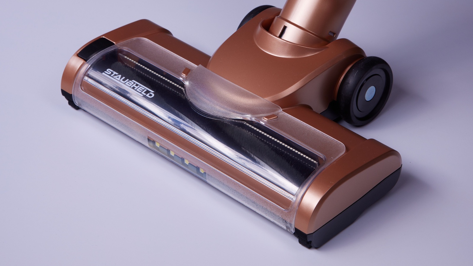 Bronze-coloured cordless vacuum floor head with a visible brush roller