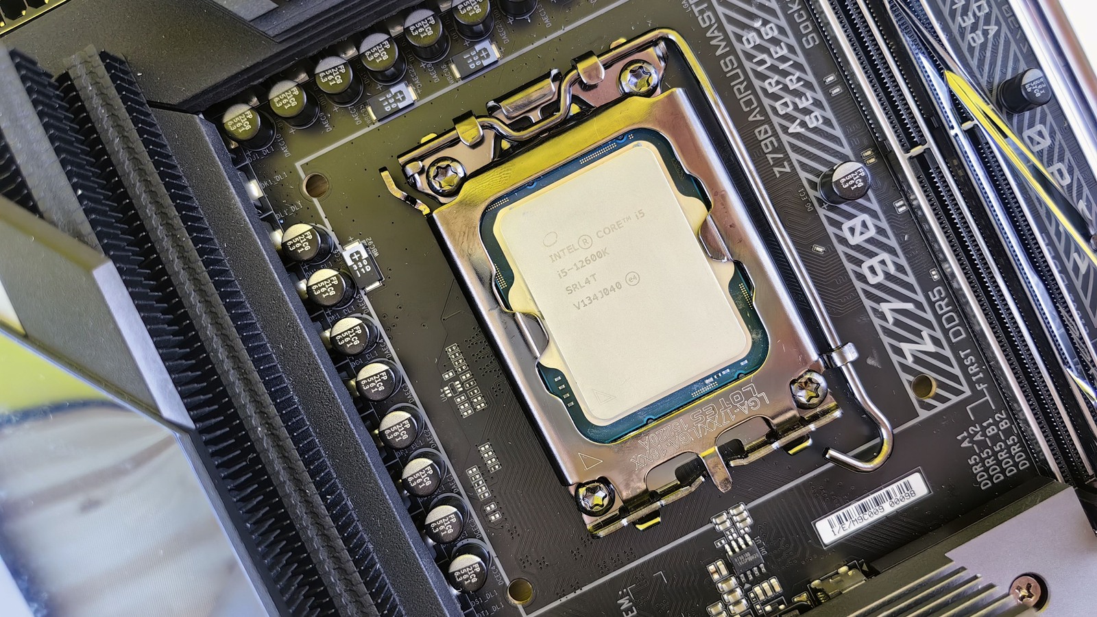 Intel Core i5-12600K desktop processor secured in a motherboard socket beside memory slots.