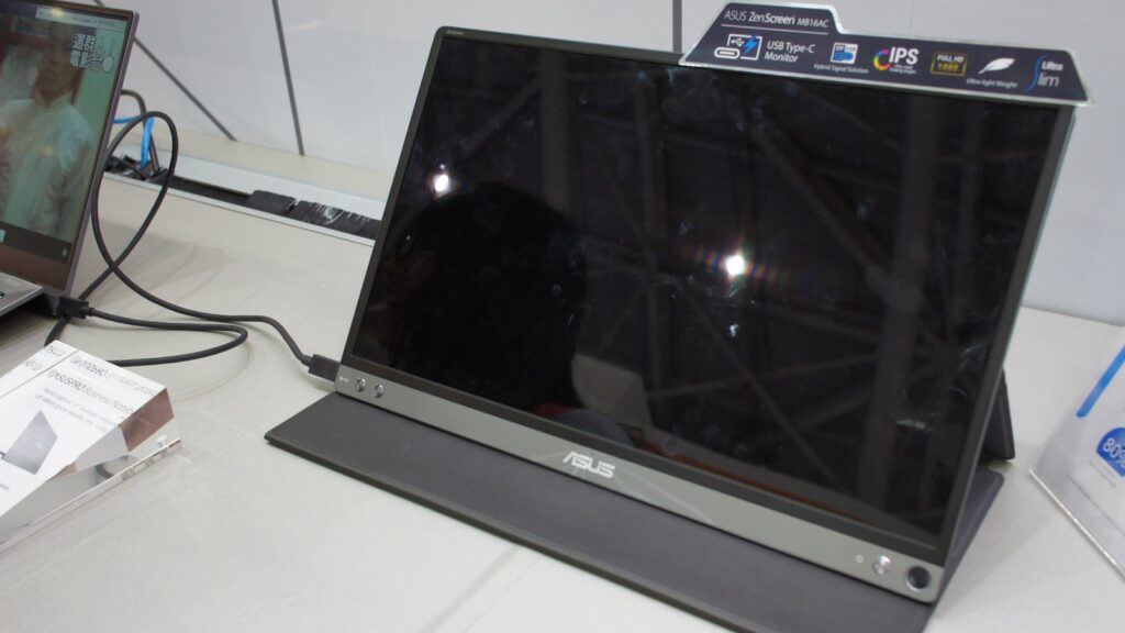ASUS ZenScreen portable monitor connected by cable beside a laptop at Computex 2017